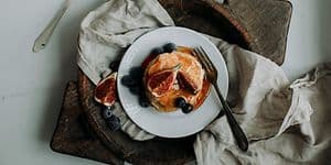 Pannukakkupäivä 2024 - Yläbanneri - Pino pannukakkuja siirapilla, viikunoilla ja mustikoilla