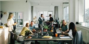 A group of employees in open office landscape, having discussions in smaller group
