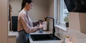 Afkalkning af kaffemaskine foretages af kvinde i et køkken