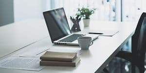 Moderne kontorinteriør med bærbar computer på skrivebordet