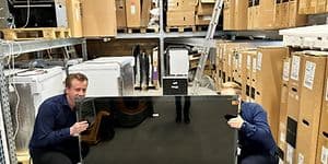 Two men picking up TV