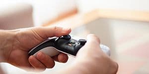 Mann som holder PlayStation 5 -kontroller i hendene