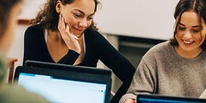 Unge kvinder med AI-PC'er i studiemiljø