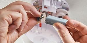 Hender setter i batteri i røykvarsler