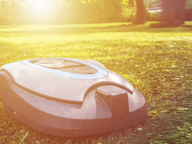 robotgressklipper på gressplen i solskinn