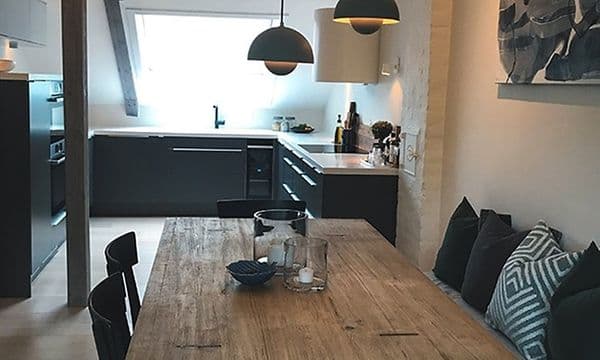 spisebord i tre på et sort epoq-kjøkken
