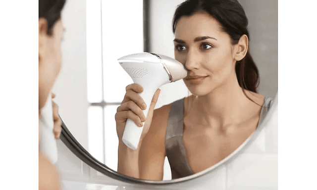 Kvinne bruker Philips Lumea Prestige i ansiktet