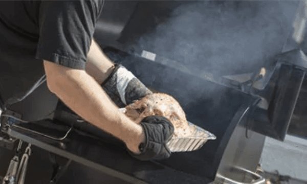 mann plasserer mat på grill for røking