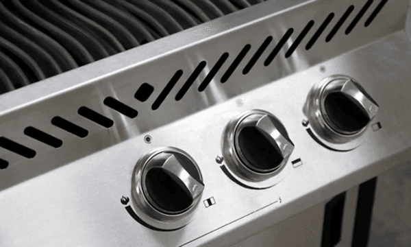 Svarta vred på en gasgrill i silver. 