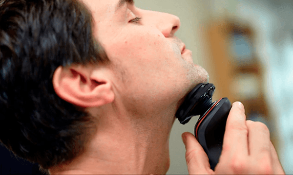 mann bruker Philips Series 5000 barbermaskin på hake
