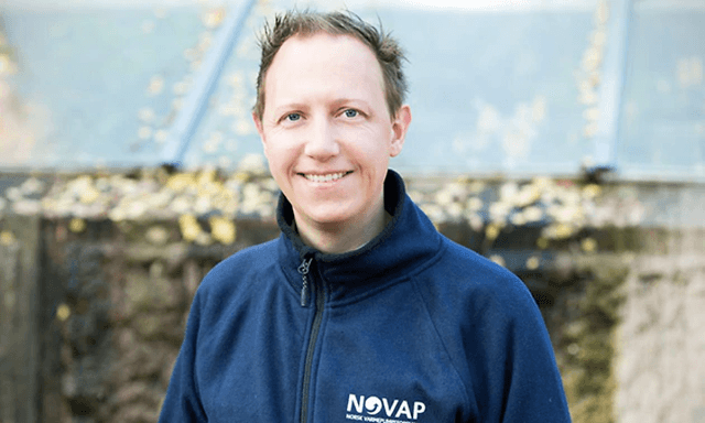 smilende mann med jakke med NOVA- logo på
