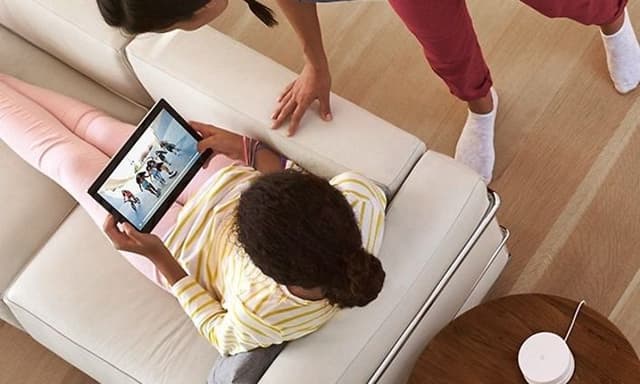 Tyttö tabletti sylissään katselevat videota yhdessä naisen kanssa