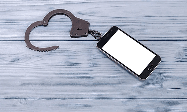smarttelefon med håndjern ved siden av