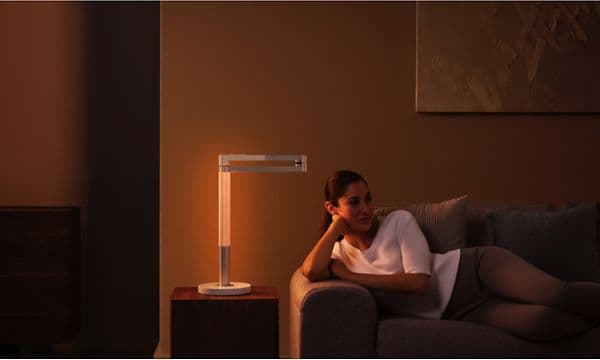Kvinne som slapper av på en sofa med en Dyson Lightcycle Morph på et bord