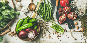 Flatlay foto av grönsaker, frukt och kryddor på ett bord.