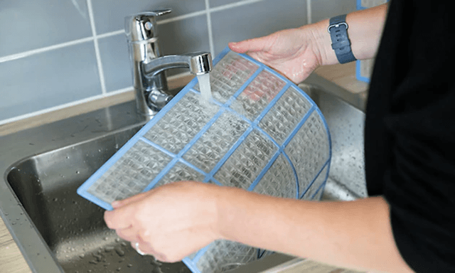 Varmepumpe filter der bliver vasket under hanen