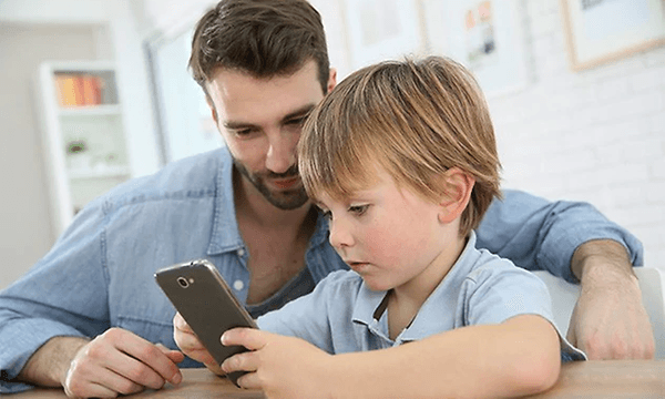 Dreng og mand der kigger på en smartphone