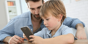 Dreng og mand der kigger på en smartphone