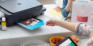 Person der tager papir ud af en printer