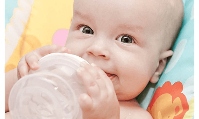 Baby der drikker i sengen