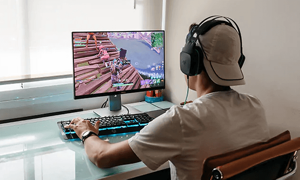 Ung mand med et headset på foran sin computer