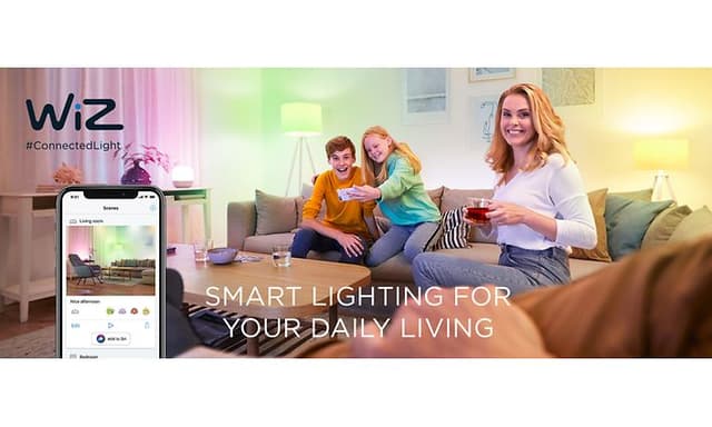 En familie sidder i en sofa og styrer lamperne via en app