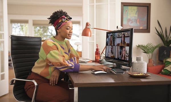Kvinde, der arbejder hjemme og deltager i et videomøde