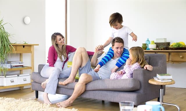 Familie i stua med detektor på veggen