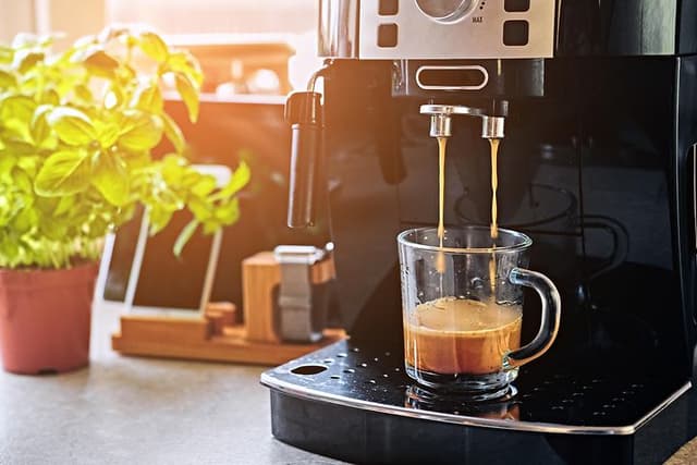 Kaffemaskin på en benk med en kopp espresso