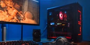Gaming - PC-setup med skärm, skrivbord, tangentbord och hörlurar.