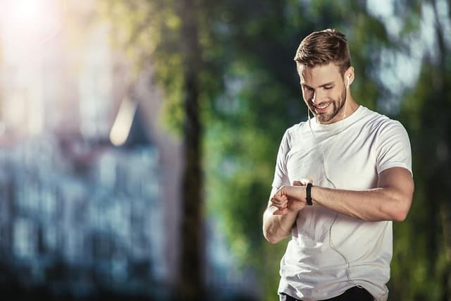 En mann som bruker en sportsklokke til trening