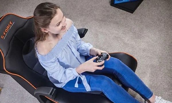 Kvinne sitter i en X Rocker gaming-stol og spiller et konsoll-spill