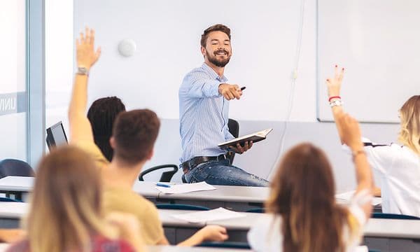 Airthings Wave Plus på en væg  i et klasselokale bag en lærer og elever 