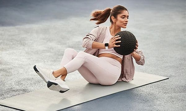 Nainen treenaa Fitbit-älykello ranteessaan