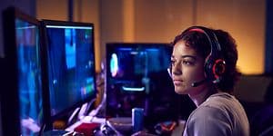 Kvinne med gaming-headset som sitter foran en stasjonær gaming-PC