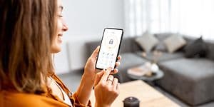 En dame låser døren med mobiltelefonen