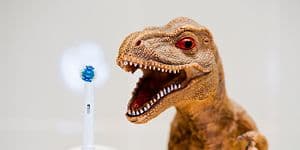 Eltandborste bredvid en dinosaurieleksak