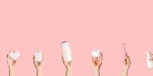 Händer som håller olika hårborttagningsprodukter som epilator, rakapparat, rakhyvel och IPL