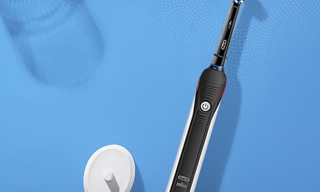 Oral-B Pro 2 -sähköhammasharja ja laturi sinisellä taustalla