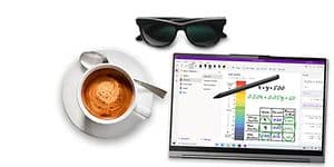 En  brettbar PC med en penn ved siden av en kaffekopp og solbriller