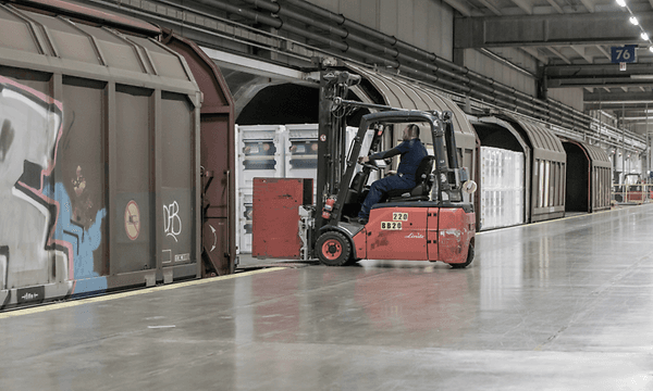 En truck som kjører kasser inn i et transporttog
