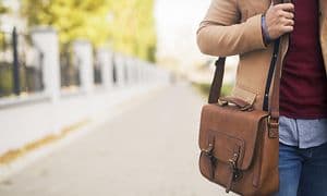Businessmann holder en PC-veske over skulderen