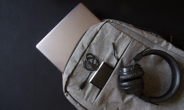 Grå ryggsekk med headsett og PC oppi