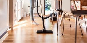 Woman using the vacuum cleaner in the kitchen
