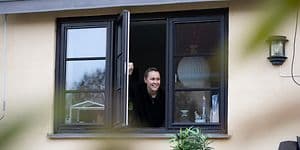 En kvinna som på avstånd öppnar ett fönster