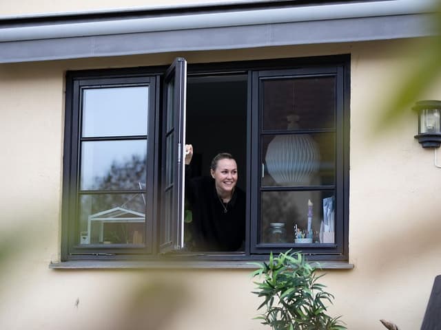 En kvinde, der åbner et vindue på afstand
