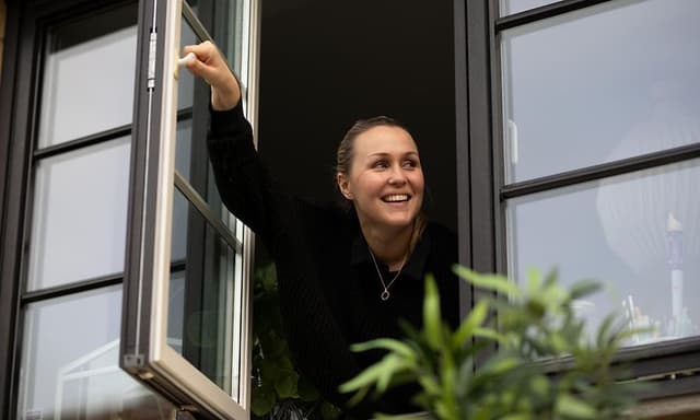 En kvinne åpner et vindu