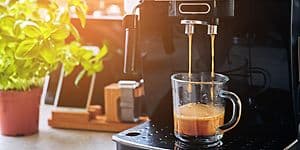 Kaffemaskin på ett bord och en kopp kaffe