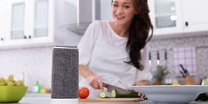 En dame lager mat og bruker en stemmestyrt assistent