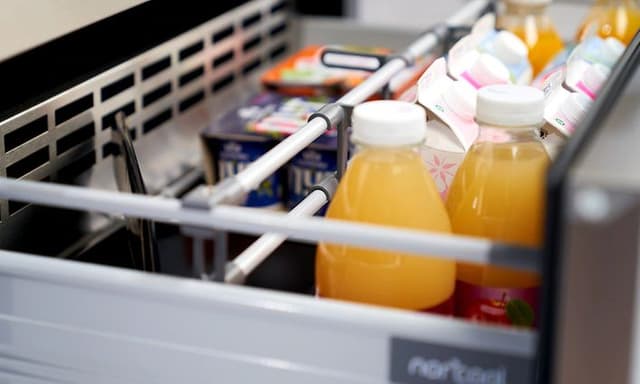 Utdragbar kylande låda från Norcool, med youghurtbägare, mjölkpaket och apelsinjuice på flaska.